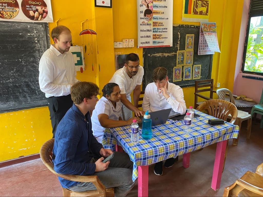Devotta interns and a health worker review the Growth Chart plugin together in Sri Lanka